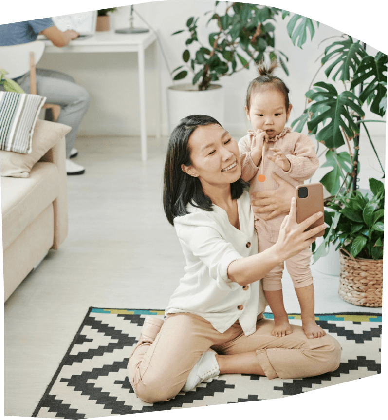Woman packing a baby snowsuit while her child plays nearby